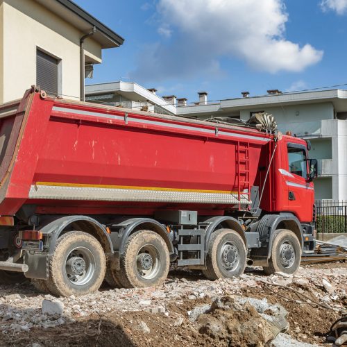 Truck on construction site. Trucking on construction concept. Tipper loaded with concrete bricks, building site. For construction theme illustrating.